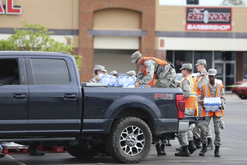 Members of the Civil Air Patrol load water for Hurricane Helene relief into a pickup truck at a water station in Augusta, Ga., on Tuesday, Oct. 1, 2024. (AP Photo/Jeffrey Collins)