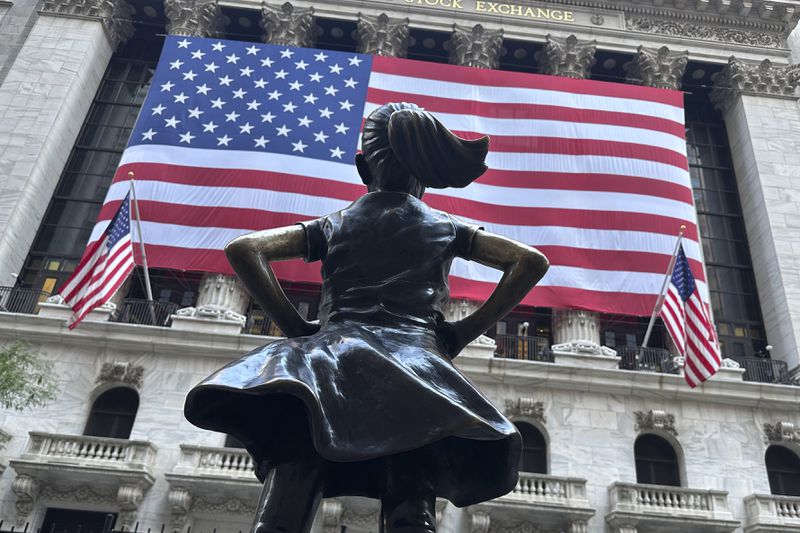 The Fearless Girl statues faces the New York Stock Exchange on July 2, 2024, in New York. Global stocks are mostly lower after benchmarks ended higher on Wall Street. (AP Photo/Peter Morgan)