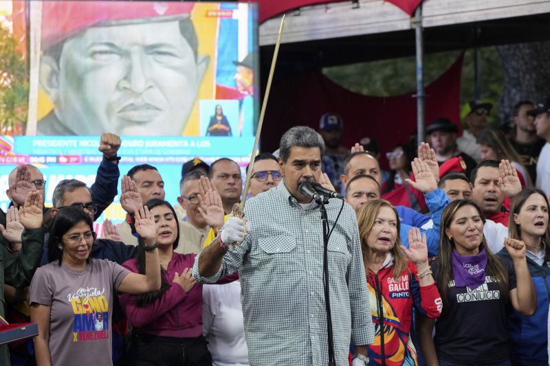 Venezuela's President Nicolás Maduro brandishes a sword as his new Cabinet takes the oath of office, at the presidential palace in Caracas, Venezuela, Wednesday, Aug. 28, 2024. (AP Photo/Ariana Cubillos)