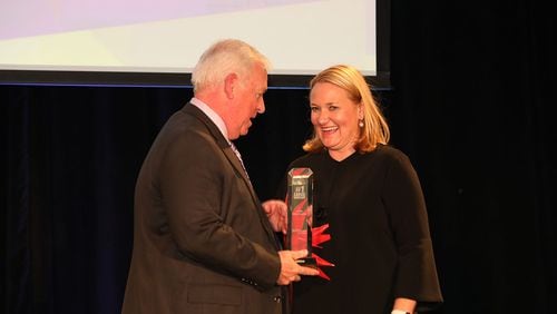 Emily Thomas Kendrick, Arrow’s president and CEO, accepts the award for top large workplace from AJC editor Kevin Riley.