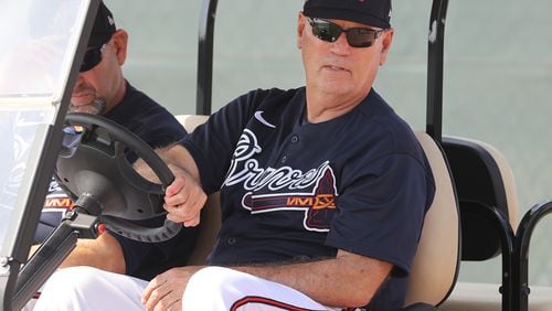 Braves manager Brian Snitker takes in the scene from his golf cart early in spring training.