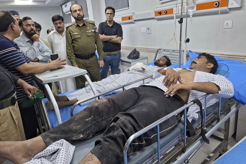 Pakistani officials inquire the health of police officers, who were wounded in gunmen ambush on a police convoy in a deserted area, at a hospital in Rahim Yar Khan, Pakistan, Friday, Aug. 23, 2024. (AP Photo/Saddique Baloch)