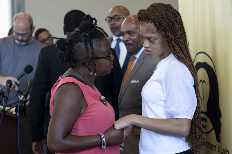 Wanda Garneaux (left) talks with Secoriea Turner’s mother Charmaine after the announcement of a scholarship in the slain child's name.
