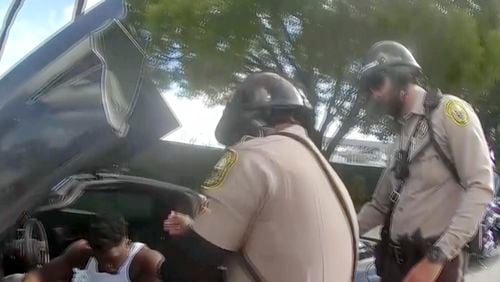 Police body camera video shows that an officer dragging Miami Dolphins wide receiver Tyreek Hill out of his sports car by his arm and head and then forcing him face first onto the ground after Hill put up the window of his sports car. (Miami-Dade Police Department)