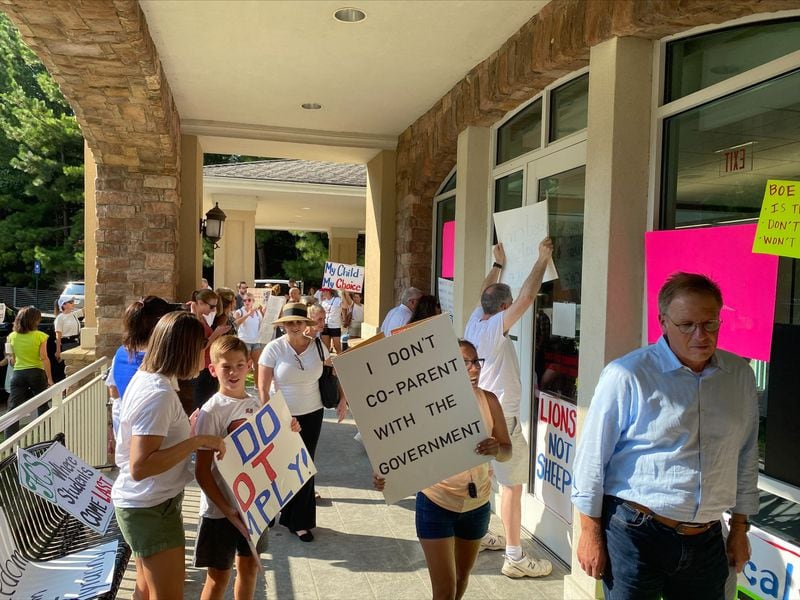 People opposed to Fulton County Schools' mask mandate protest outside a board meeting on Thursday, Aug. 12, 2021. VANESSA McCRAY/AJC