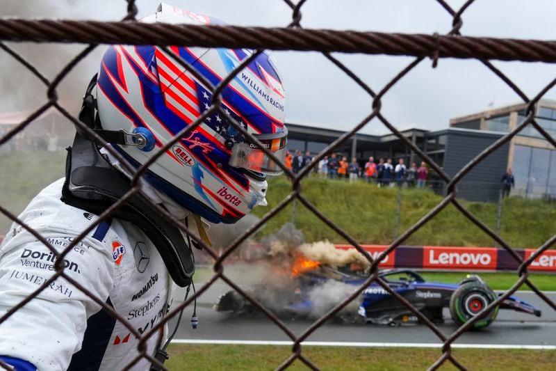 Williams driver Logan Sargeant of the US looks at his burning car after a crash during the third free practice ahead of the Formula One Dutch Grand Prix race at the Zandvoort racetrack, Netherlands, Saturday, Aug. 24, 2024. (AP Photo/Peter Dejong)