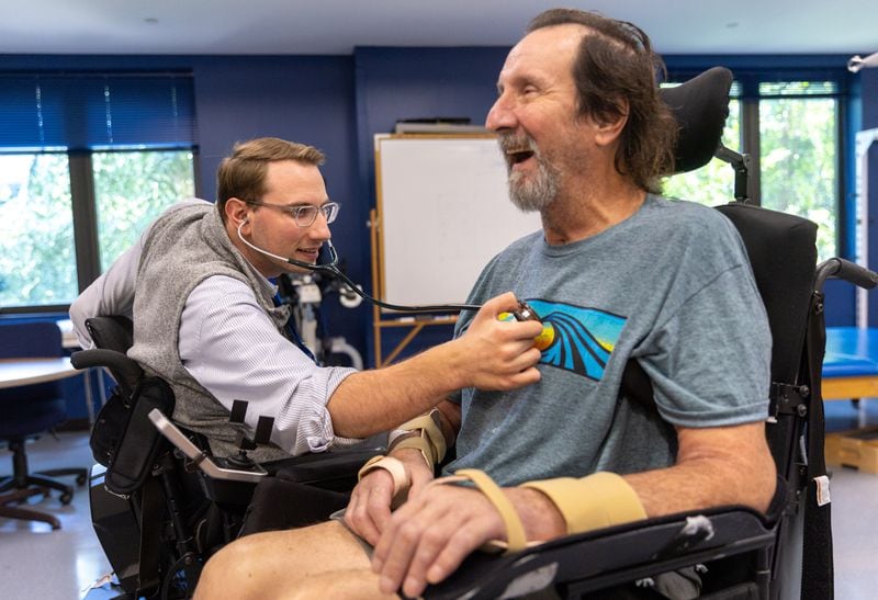 Dr. Woody Morgan, left, examines patient Lucky Hardy, 65, at Shepherd Center, says, "I didn’t know when I got here my doctor would be in a wheelchair. I just knew I was going to see Dr. Morgan. But I felt a connection like maybe he can feel my pain. He knows what I am going through." (Arvin Temkar / arvin.temkar@ajc.com)