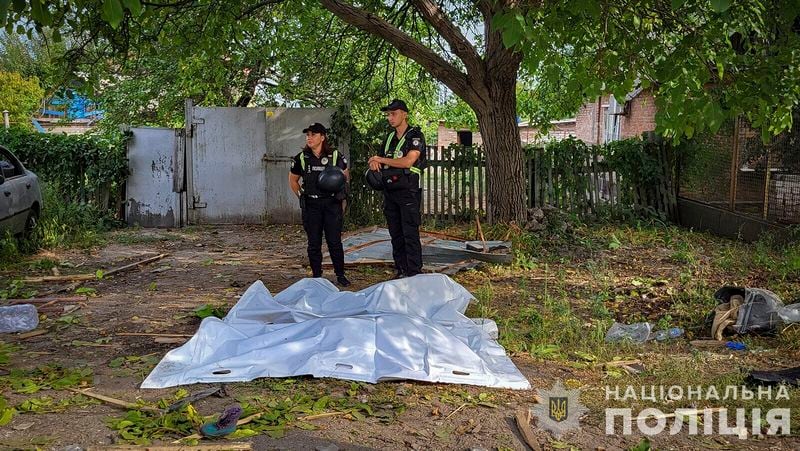 In this photo provided by the National Police of Ukraine on Tuesday, August 27, 2024, Police offices stand next to bodies covered with plastic bags after Russian airstrike in Zaporizhzhia, Ukraine. (National Police of Ukraine via AP)