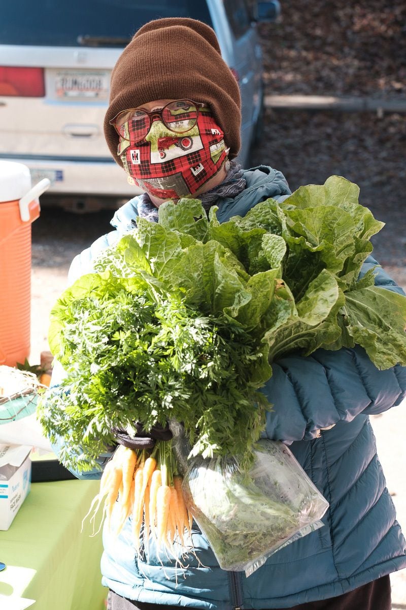 A masked shopper holds arms full of greens purchased at the Green Market at Piedmont Park.
Courtesy of Kevin Segedi