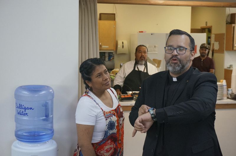 Lizete Vega, church council president, left, her husband, Delfino Gomez, background center, and the Rev. Hierald Osorto, foreground right, prepare for a taco lunch after Sunday worship at Iglesia Luterana San Pablo in Minneapolis, on Sept. 8, 2024. (AP Photo/Giovanna Dell'Orto)