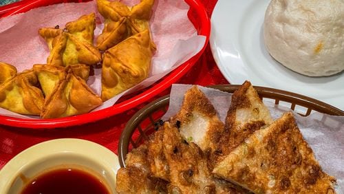 Crab rangoon, a sweet steamed bun and a scallion pancake all served as impressive supporting players at Dumpling Factory. (Henri Hollis/AJC)