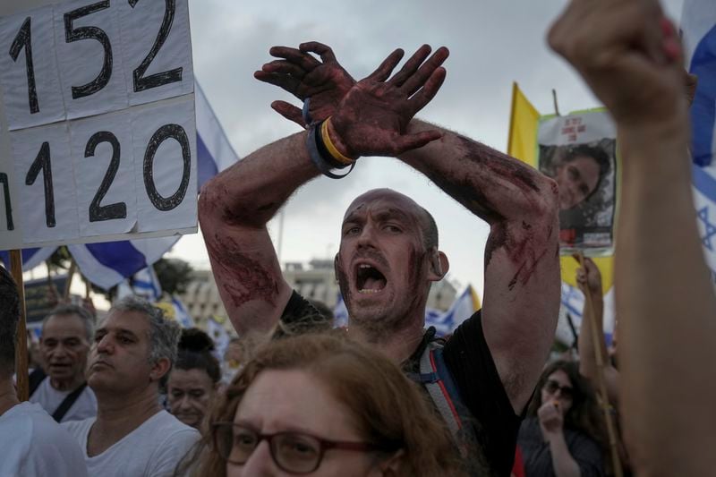 Family members and supporters of the hostages held captive by Hamas in Gaza complete the final leg of a four-day march from Tel Aviv to Jerusalem to demand the immediate release of all hostages, outside the Prime Minister's office in Jerusalem on Saturday, July 13, 2024. (AP Photo/Mahmoud Illean)