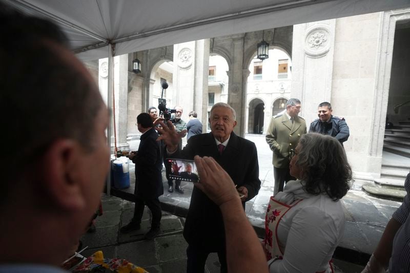 Mexican President Andres Manuel Lopez Obrador speaks to the press holding a plate of tamales after finishing his last morning press conference, "La Mañanera," at the National Palace in Mexico City, Monday, Sept. 30, 2024. (AP Photo/Fernando Llano)