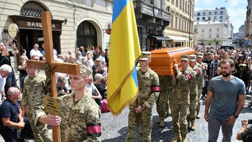 Soldiers carry the coffin of former Ukrainian nationalist lawmaker Iryna Farion during a funeral ceremony in Lviv, Ukraine, Monday, July 22, 2024. Farion, who often made outspoken statements defending the Ukrainian language was shot by a gunman in her home city of Lviv. (AP Photo/Mykola Tys)