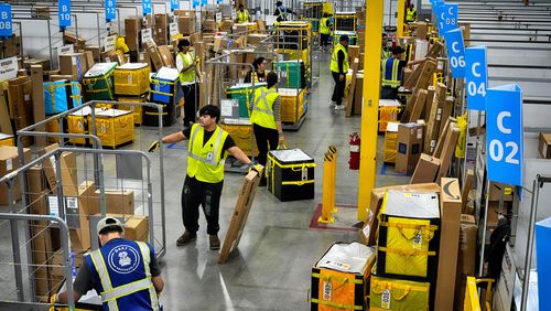FILE - Amazon employees load packages on carts before being put on to trucks for distribution for Amazon's annual Prime Day event at an Amazon's DAX7 delivery station on Tuesday, July 16, 2024, in South Gate, Calif. (AP Photo/Richard Vogel, File)