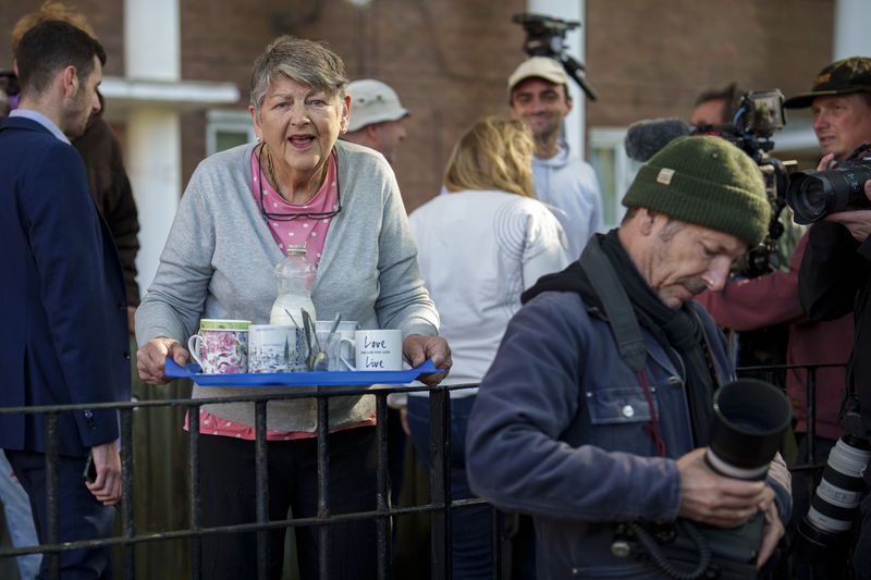 A woman holds a tray after offering hot drinks to members of the media waiting for Labour Party leader Keir Starmer to vote outside a polling station in London, Thursday, July 4, 2024. Voters in the U.K. are casting their ballots in a national election to choose the 650 lawmakers who will sit in Parliament for the next five years. Outgoing Prime Minister Rishi Sunak surprised his own party on May 22 when he called the election. (AP Photo/Vadim Ghirda)