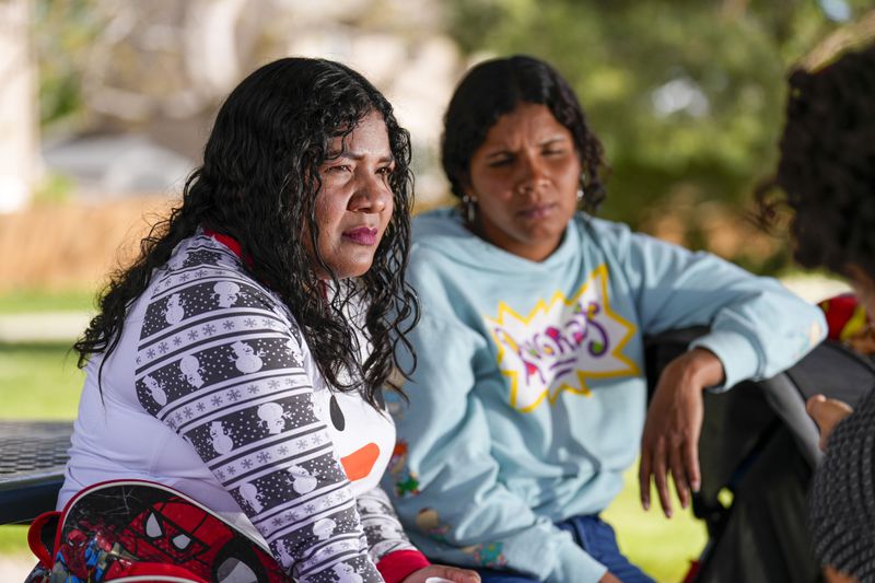 Emily Rodriguez, left, and Ivanni Herrera look on during an interview in a park Friday, May 18, 2024, in Aurora, Colo. (AP Photo/Jack Dempsey)