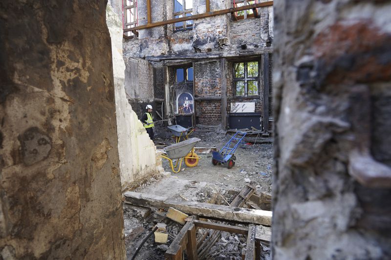 Workers clear rubble at Copenhagen's Old Stock Exchange building in Copenhagen, Denmark, Thursday, Sept. 19, 2024. (AP Photo James Brooks)