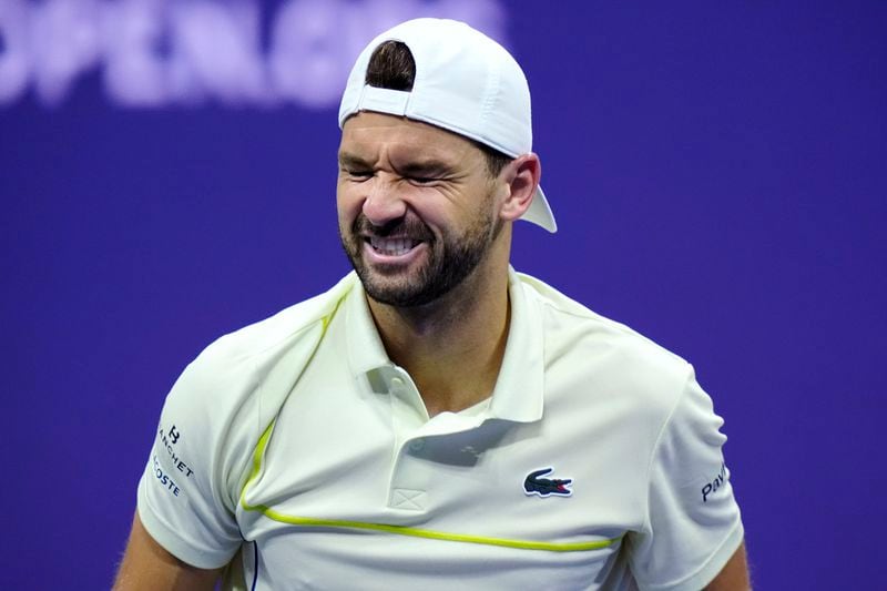 Grigor Dimitrov, of Bulgaria, winces during the fourth set of his match against Frances Tiafoe, of the United States, shortly before retiring with an apparent injury, during the quarterfinals of the U.S. Open tennis championships, Tuesday, Sept. 3, 2024, in New York. (AP Photo/Eduardo Munoz Alvarez)