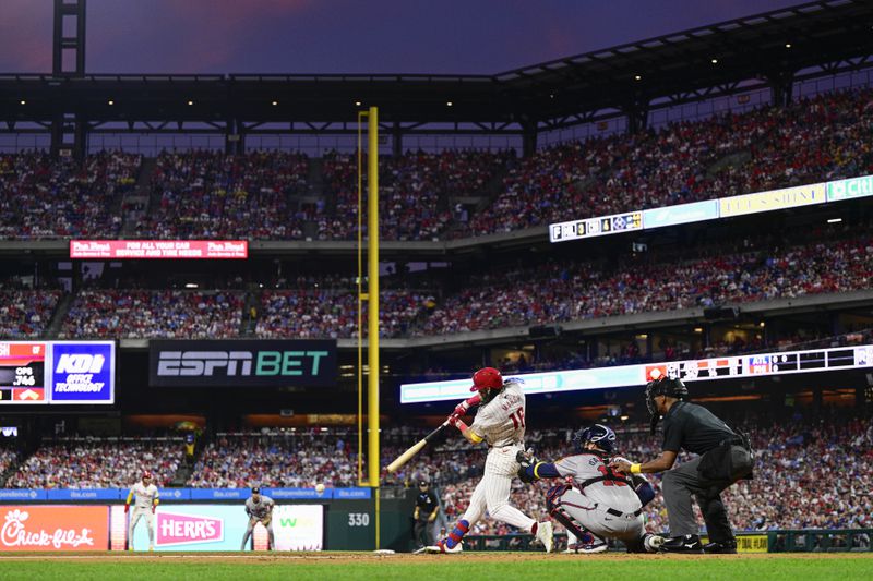 Philadelphia Phillies' Brandon Marsh, center, hits an infield single off Atlanta Braves' Spencer Schwellenbach during the second inning of a baseball game, Sunday, Sept. 1, 2024, in Philadelphia. (AP Photo/Derik Hamilton)