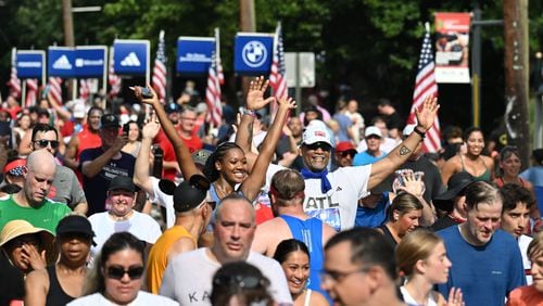 Runners celebrate at the finish of the 55th running of the Atlanta Journal-Constitution Peachtree Road,Thursday, July 4, 2024, in Atlanta. (Hyosub Shin / AJC)