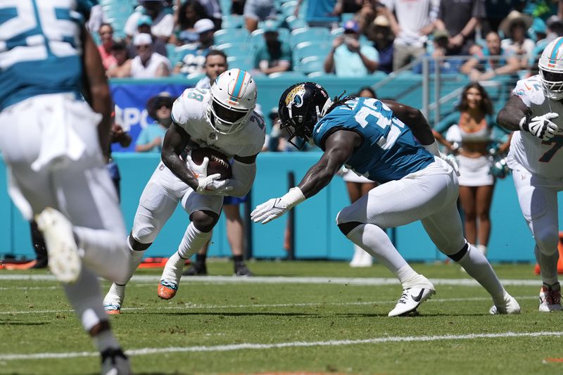 Miami Dolphins running back De'Von Achane (28) runs to score a touchdown during the first half of an NFL football game against the Jacksonville Jaguars, Sunday, Sept. 8, 2024, in Miami Gardens, Fla. (AP Photo/Rebecca Blackwell)