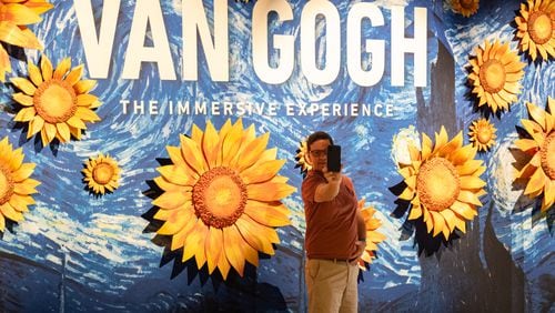 Gianni Belmonte takes a selfie at the entrance to Van Gogh: The Immersive Experience at Exhibition Hub Art Center Atlanta in Doraville on Monday, July 31, 2023.   (Ben Gray / Ben@BenGray.com)