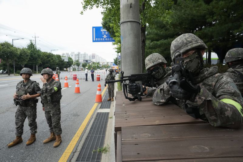 South Korean army soldiers aim their machine guns as they control traffic during a civil defense drill as a part of the Ulchi Freedom Shield military exercise between the U.S. and South Korea in Seoul, South Korea, Thursday, Aug. 22, 2024. (AP Photo/Ahn Young-joon)