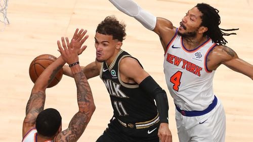 Hawks guard Trae Young passes off around the double team of New York Knicks defenders Obi Toppin (left) and Derrick Rose during Game 4 of their first-round playoff series Sunday, May 30, 2021, at State Farm Arena in Atlanta. (Curtis Compton / Curtis.Compton@ajc.com)