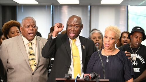 Attorney Ben Crump pumps his fist as Amos King (left) and Jonia Milburn (right), mother of Christon Collins, chant during a press conference on Tuesday, August 6, 2024 in Atlanta. The family of Christon Collins hold a press conference with attorney Ben Crump. Collins, a veteran, was found dead in the DeKalb County Jail on March 13. His mother has obtained video footage that shows her son was lying on the floor for hours before jail staff responded. (Hyosub Shin / AJC)