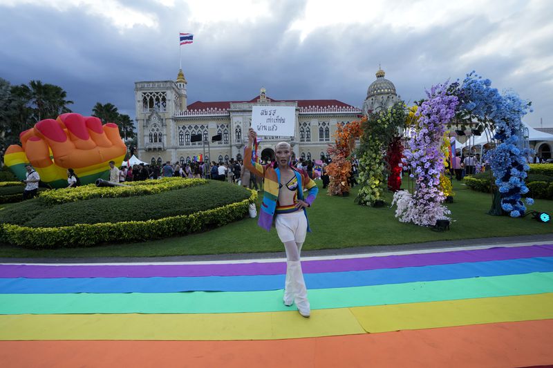 A supporter celebrates after Thailand’s Senate overwhelmingly approved a landmark bill to legalize same-sex marriages in Bangkok, Thailand, Tuesday, June 18, 2024. Banner reads, "Marriage equality law was passed by Senate". (AP Photo/Sakchai Lalit)