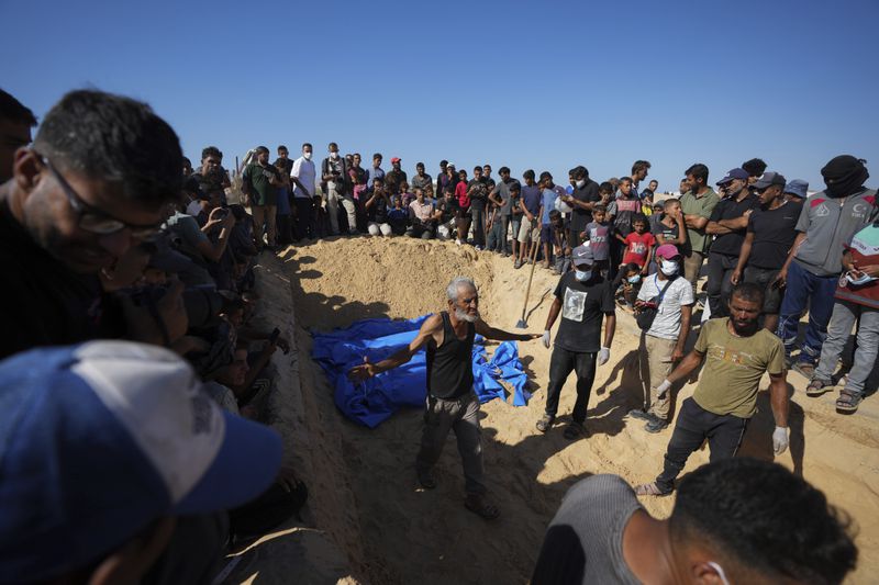 People bury the bodies of Palestinians taken by the Israeli military during operations in Gaza and returned this week, in Khan Younis, Gaza Strip, Thursday, Sept. 26, 2024. (AP Photo/Abdel Kareem Hana)