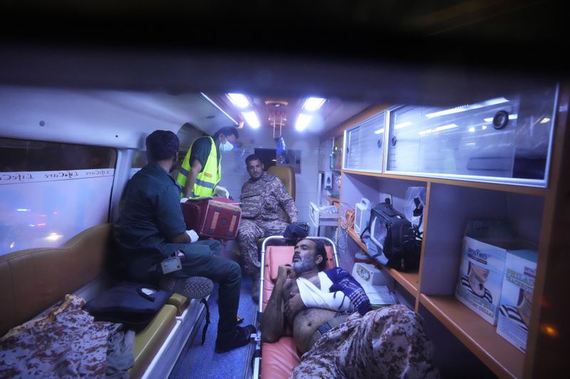 Pakistani security officials who were injured in an explosion receives treatment inside an ambulance outside the Karachi airport, Pakistan, Monday, Oct. 7, 2024. (AP Photo/Fareed Khan)