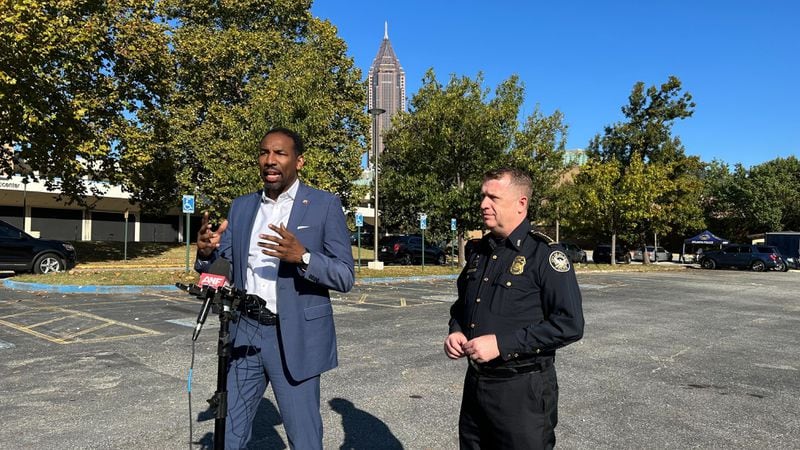 Mayor Andre Dickens (left) and Atlanta police Interim Chief Darin Schierbaum speak at Saturday's "Gun Buyback" event.