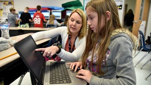 Forsyth County’s Chestatee Elementary School teacher Joy Hall helps fourth-grader Raine Wilson with a writing assignment during class. The Forsyth School Board on Oct. 8 will receive a proposed redistricting map that may affect children at Sawnee, Matt, Kelly Mill, Silver City and Coal Mountain elementary schools. AJC FILE