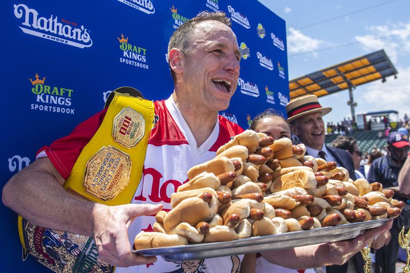 FILE - Joey Chestnut, winner of the 2021 Nathan's Famous Fourth of July International Hot Dog-Eating Contest, poses for photos in Coney Island's Maimonides Park, July 4, 2021, in the Brooklyn borough of New York. Chestnut will take his hot dog-downing talents to an army base in Texas for America's Independence Day this year, after a falling out with organizers of the annual New York City-based event. (AP Photo/Brittainy Newman, File)