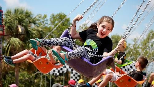 Children enjoy the Swinger ride at the North Palm Beach Heritage Day Festival in Anchorage Park Saturday, April 7, 2018. Following a Parade featuring bands, civic groups, clubs and organizations from the area, the Festival at Anchorage Park featured a business expo, carnival rides, food and drinks,
games, musical entertainment, a cornhole tournament, and more. (Bruce R. Bennett / The Palm Beach Post)