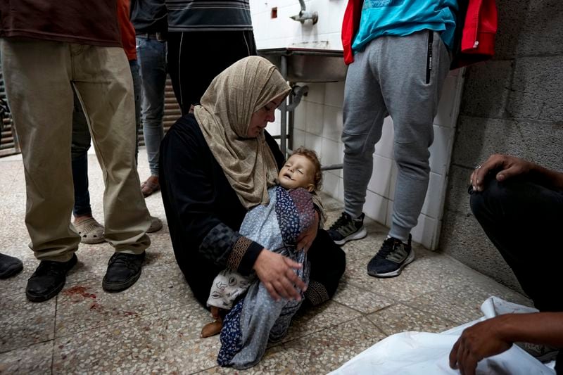 A Palestinian woman mourns a child killed in the Israeli bombardment of the Gaza Strip at a hospital morgue in Deir al-Balah, Wednesday, Oct. 2, 2024. (AP Photo/Abdel Kareem Hana)