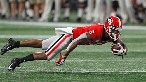 12/1/18 - Atlanta -  Georgia Bulldogs wide receiver Terry Godwin (5) dives forward for a first down after a catch during the first half.  The University of Georgia Bulldogs played the Alabama Crimson Tide in a NCAA college football game for the Southeastern Conference Championship Saturday, Dec. 1, 2018, at Mercedes-Benz  Stadium in Atlanta, GA.      BOB ANDRES / BANDRES@AJC.COM