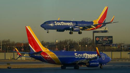 FILE - A Southwest Airlines plane prepares to land at Midway International Airport while another taxis on the ground, Feb. 12, 2023, in Chicago. (AP Photo/Kiichiro Sato, File)