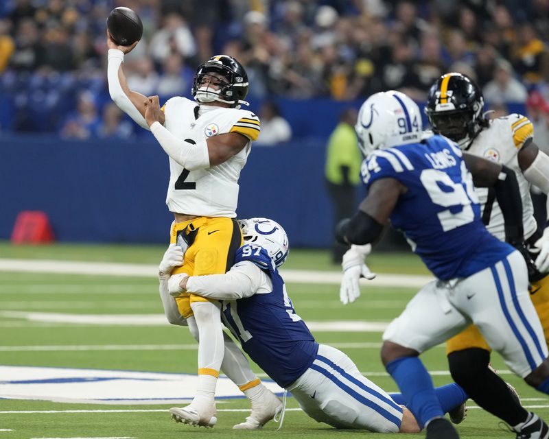 Pittsburgh Steelers quarterback Justin Fields (2) gets off a pass as he is hit by Indianapolis Colts defensive end Laiatu Latu (97) during the second half of an NFL football game Sunday, Sept. 29, 2024, in Indianapolis. (AP Photo/Darron Cummings)