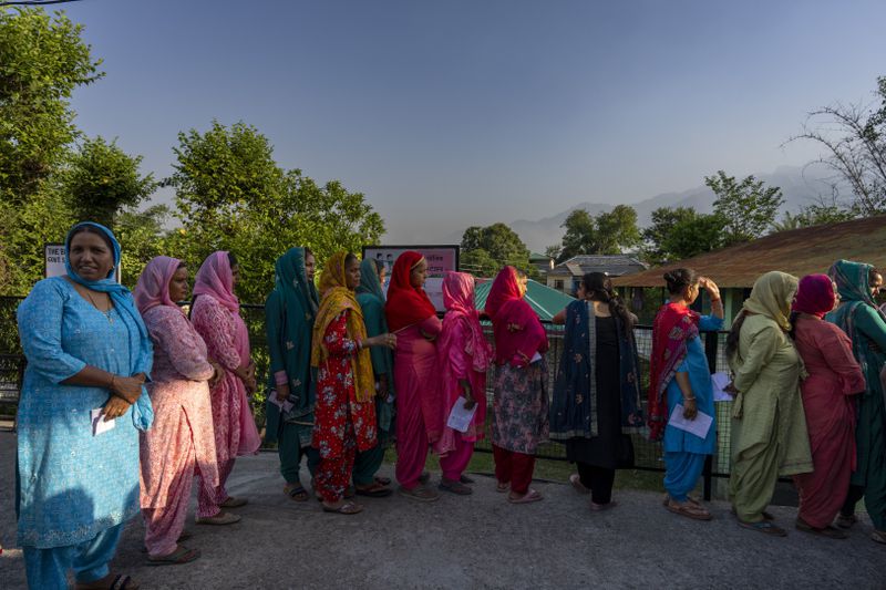 The sun rises behind the Dhauladhar range of the Himalaya as people form queues to cast their vote during the last round of a six week-long national election in Dharamshala, India, Saturday, June 1, 2024. The seventh round of voting in 57 constituencies across seven states and one union territory will complete polling for all 543 seats in the powerful lower house of parliament. Nearly 970 million voters more than 10% of the world’s population were eligible to elect a new parliament for five years. (AP Photo/Ashwini Bhatia)