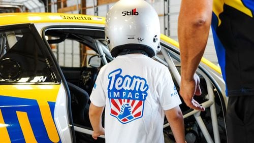 A Team IMPACT-matched child prepares for their turn racing on the Thompson Speedway track in Thompson, Connecticut, with a professional racecar driver. (Courtesy Team IMPACT)