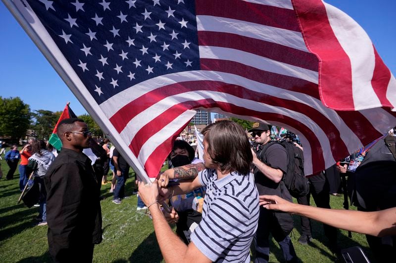 Demonstrators clash with counter protesters over the flag at a rally in Union Park during the Democratic National Convention Wednesday, Aug. 21, 2024, in Chicago. (AP Photo/Alex Brandon)