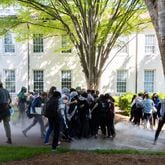Pro-Palestinian protesters who set up an encampment flee nonlethal ammunition deployed by police at Emory University in Atlanta on April 25, 2024. (Arvin Temkar / AJC)