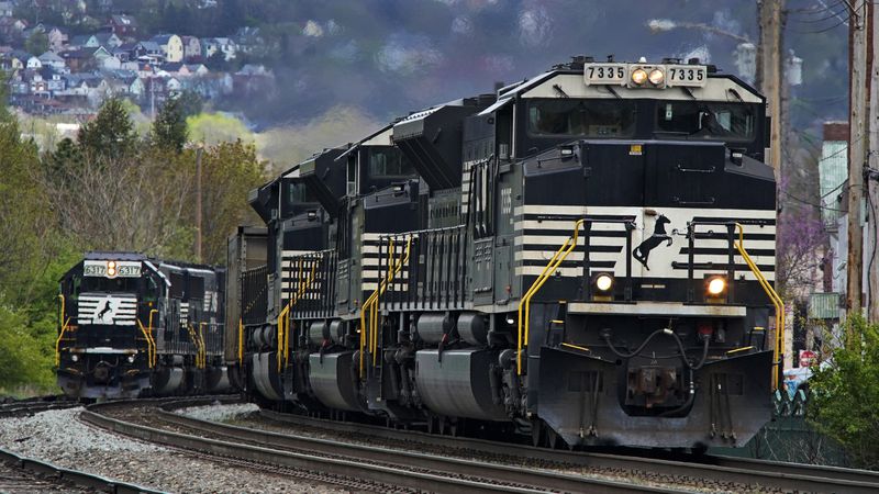 FILE - A Norfolk Southern freight train passes a train on a siding as it approaches a crossing in Homestead, Pa, Wednesday, April 27, 2022. (AP Photo/Gene J. Puskar, File)