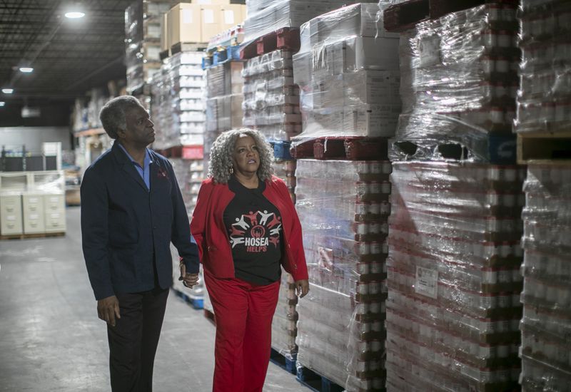 Elisabeth and Afemo Omilami, who run the nonprofit Hosea Helps, tour the warehouse area at the new facility for the organization. (Bob Andres / bandres@ajc.com)