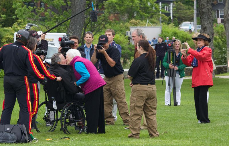 FILE PHOTO: Former first lady Barbara Bush greets her husband and former U.S. President George H.W. Bush with a kiss after his successful skydive down to St. Anne's Episcopal Church on June 12, 2014 in Kennebunkport, Maine. The President is celebrating his 90th birthday today.   (Photo by Eric Shea/Getty Images)