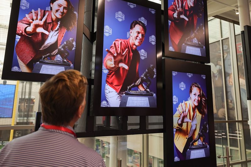 Jeff Wansley looks at his face at The Champions & Contenders exhibit that is part of new GAME ON! AI Experience at The College Football Hall of Fame in Atlanta on Friday, Aug. 23, 2024. GAME ON! uses generative AI to collect information to gives guests a customized fan experience throughout the exhibits. (Natrice Miller/ AJC)