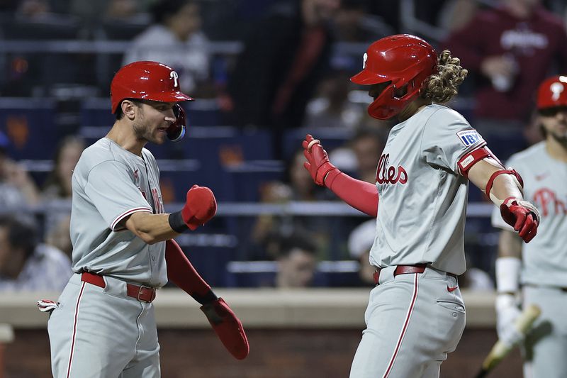 Philadelphia Phillies' Alec Bohm is congratulated by Trea Turner, left, after hitting a three-run home run during the fourth inning of a baseball game against the New York Mets, Friday, Sept. 20, 2024, in New York. (AP Photo/Adam Hunger)